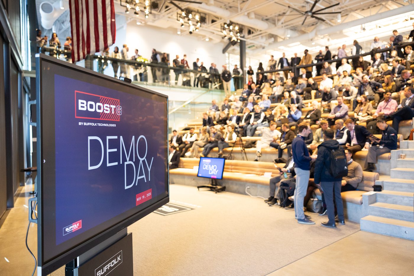 Attendees filling the tiered seating at BOOST Demo Day