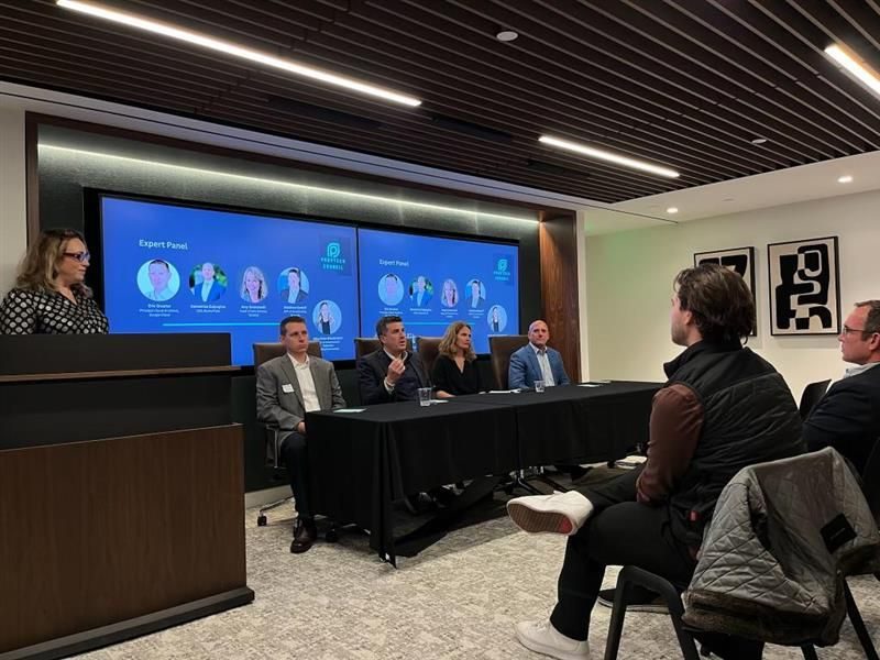 Panel of industry leaders speaking to a seated audience